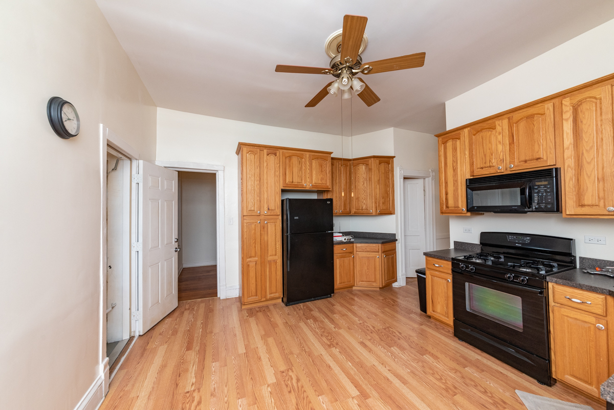 3300 North Racine Avenue, Unit 3 Chicago, IL 60657 - Photo 14 of 17 a kitchen with a refrigerator a stove top oven a sink dishwasher and wooden cabinets