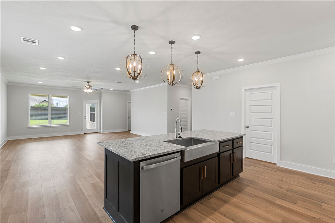 5008 Toscana Loop Bryan, TX 77802 - Photo 12 of 33 a kitchen with a sink chandelier and wooden floor