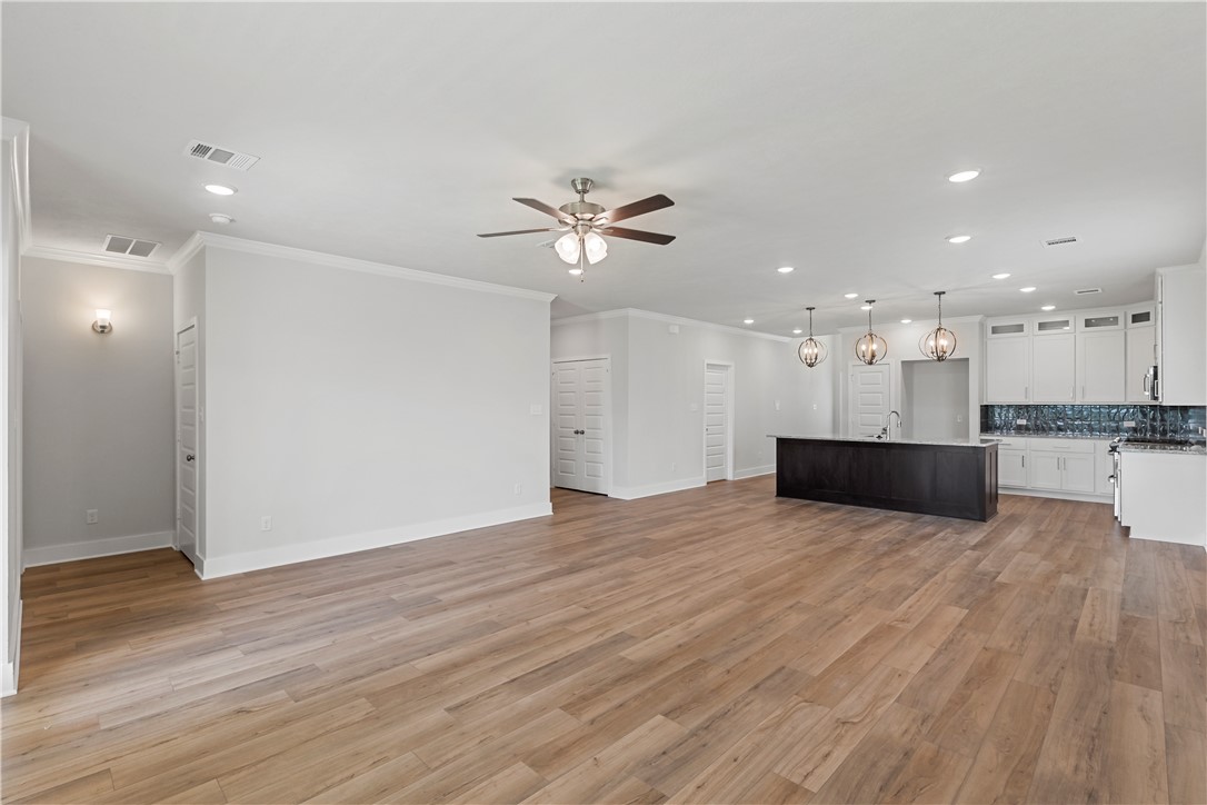 5008 Toscana Loop Bryan, TX 77802 - Photo 17 of 33 a view of an empty room with wooden floor and a kitchen
