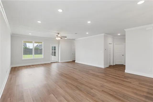 an empty room with windows and fan