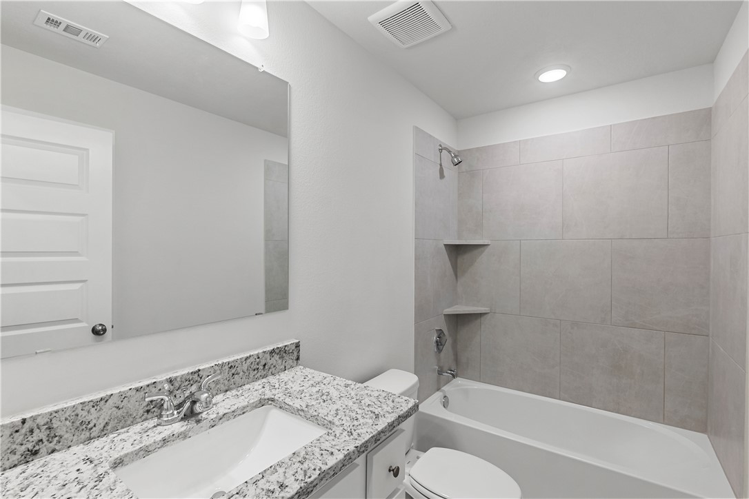 5008 Toscana Loop Bryan, TX 77802 - Photo 20 of 33 a bathroom with a granite countertop sink toilet and shower
