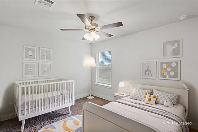 an empty room with windows and fan