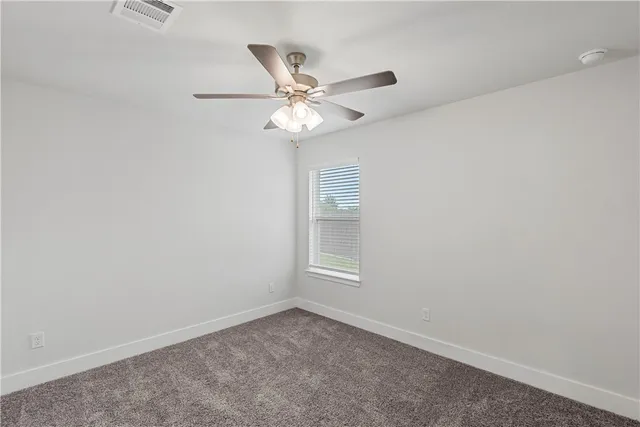 an empty room with closet and fan