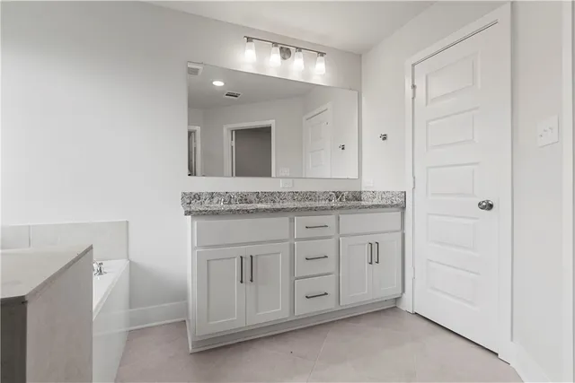 a bathroom with a tub sink and mirror