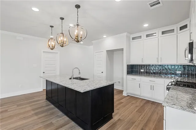 a kitchen with granite countertop a stove a sink and a microwave