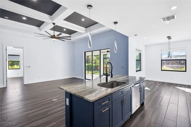 a kitchen with granite countertop a sink cabinets and wooden floor