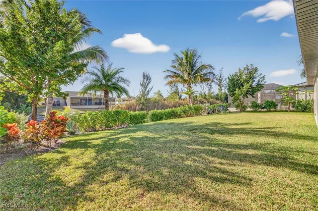 a view of a house with a yard and potted plants