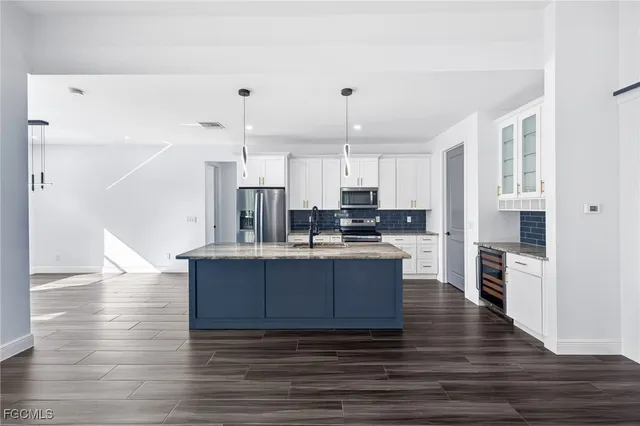a kitchen with stainless steel appliances a refrigerator and a stove top oven