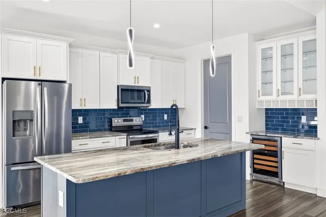 a kitchen with kitchen island granite countertop a sink stove and refrigerator