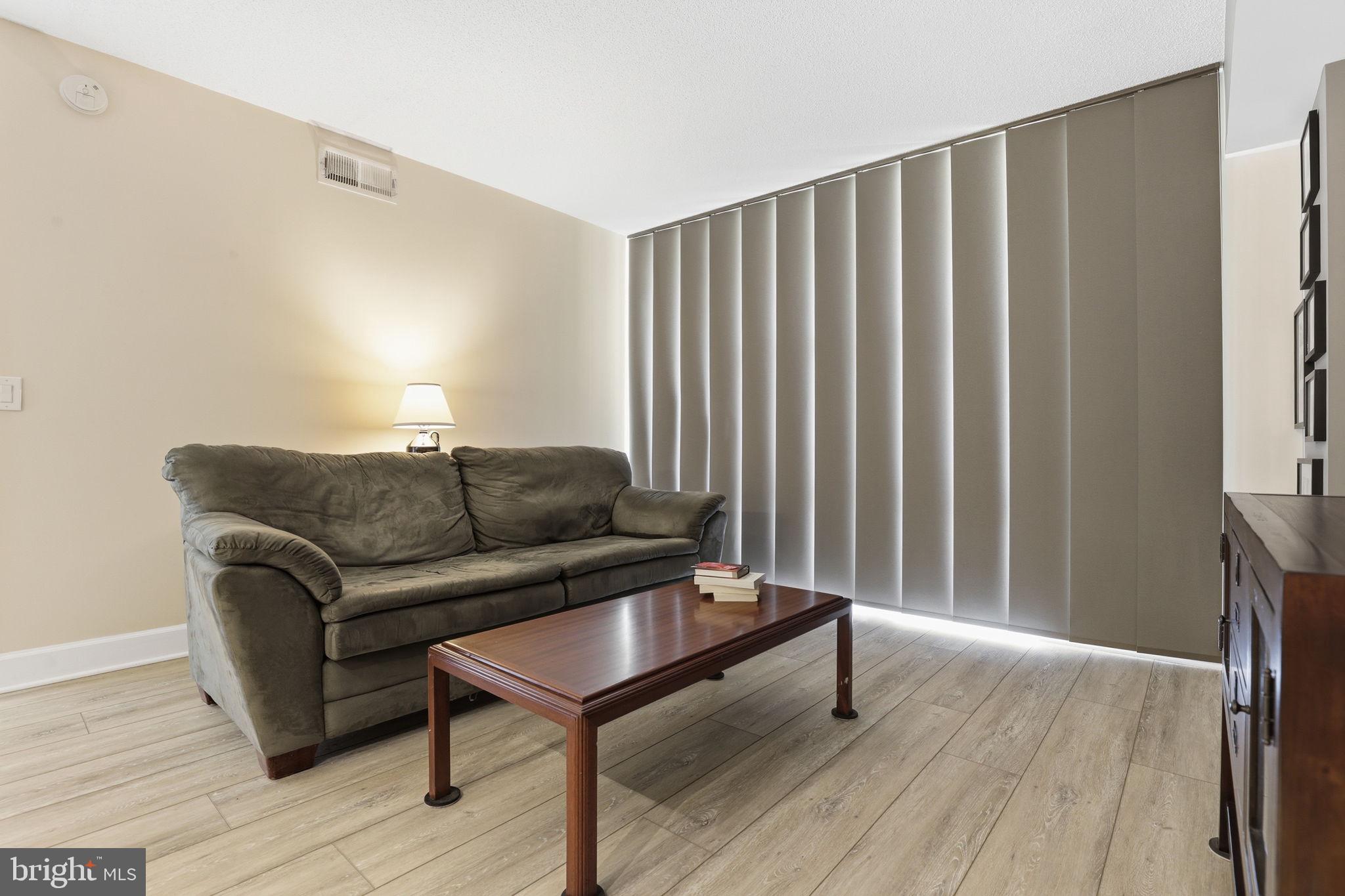 11800 Sunset Hills Road, Unit 218 Reston, VA 20190 - Photo 9 of 38 a living room with furniture and a wooden floor