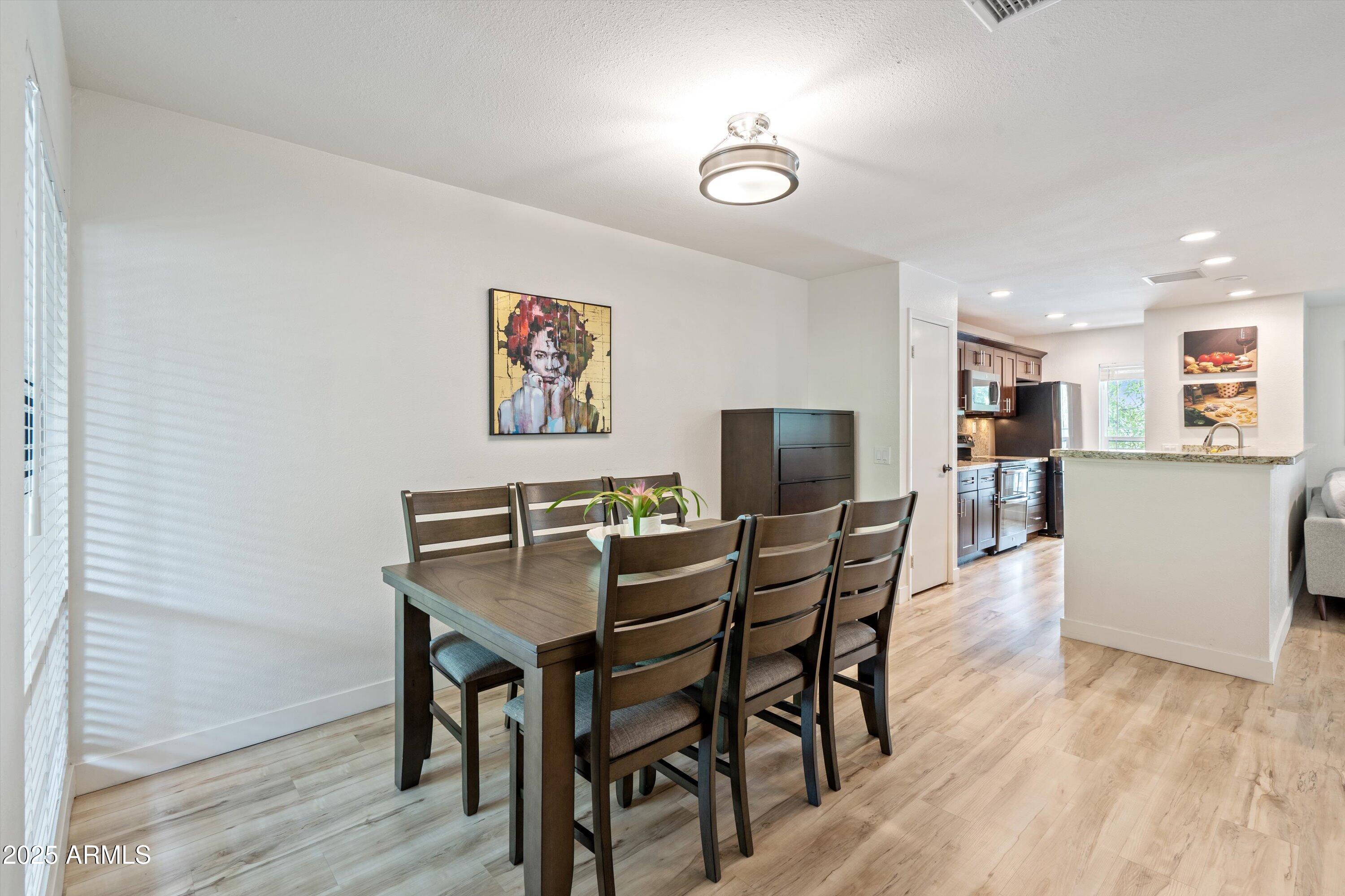 5201 North 24th Street, Unit 206 Phoenix, AZ 85016 - Photo 18 of 39 a view of a dining room with furniture and wooden floor