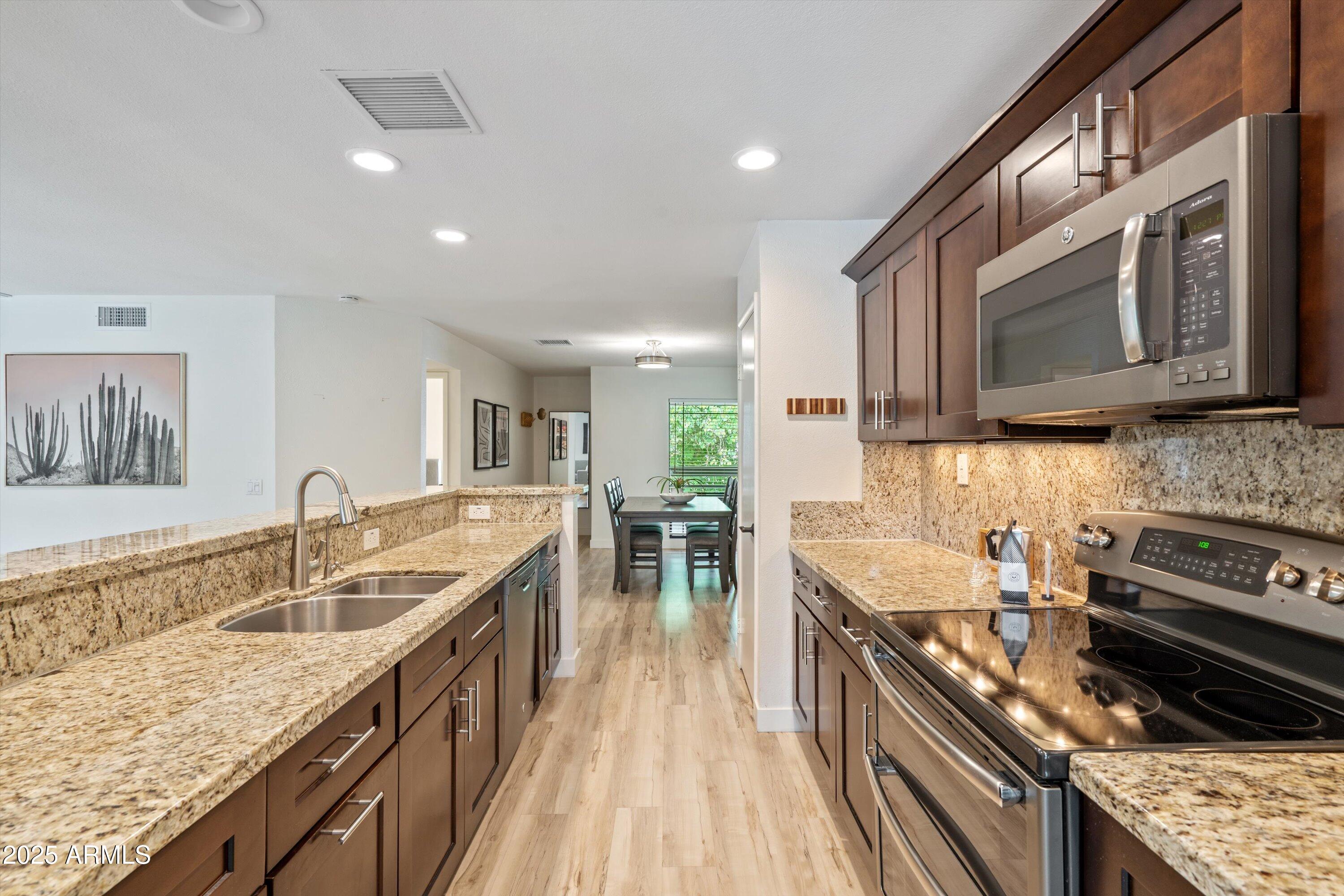 5201 North 24th Street, Unit 206 Phoenix, AZ 85016 - Photo 20 of 39 a kitchen with stainless steel appliances granite countertop a sink stove and refrigerator