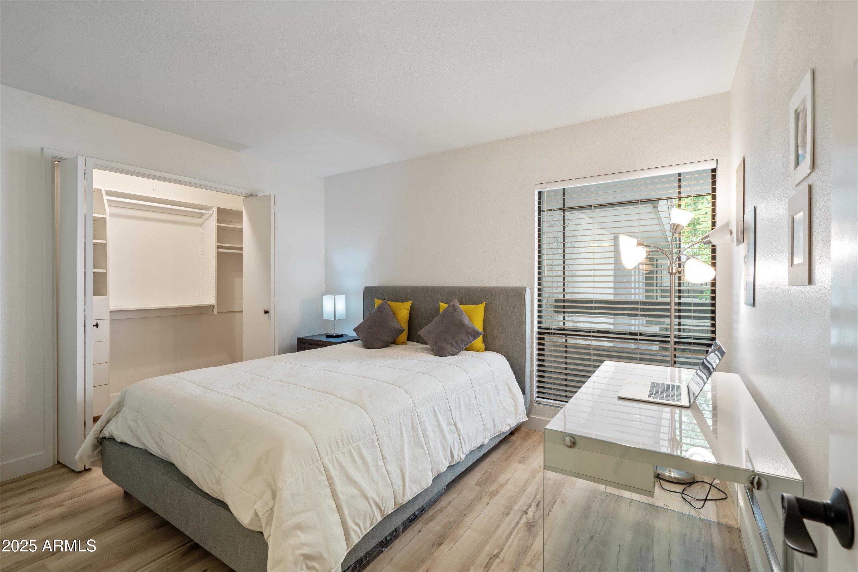 5201 North 24th Street, Unit 206 Phoenix, AZ 85016 - Photo 23 of 39 a bedroom with a bed and wooden floor