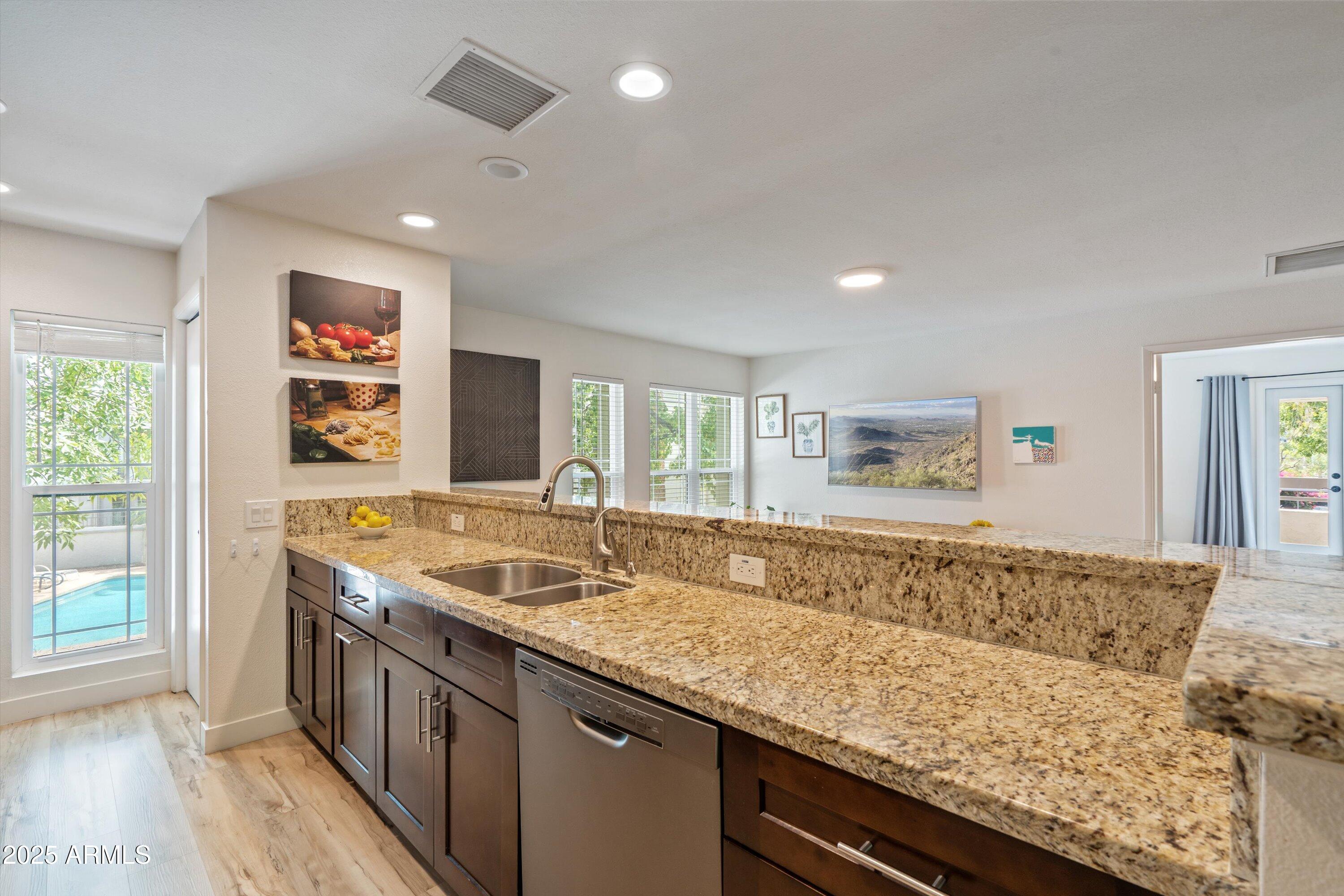 5201 North 24th Street, Unit 206 Phoenix, AZ 85016 - Photo 5 of 39 a view of kitchen island a sink wooden floor and a window
