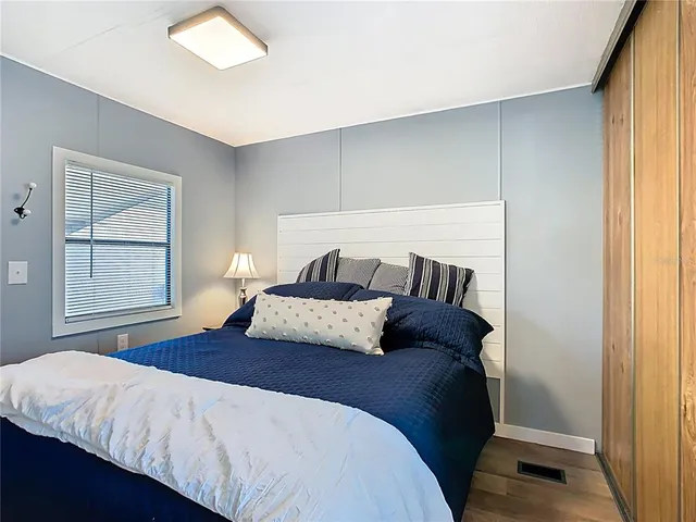 a bedroom with a bed and wooden floor