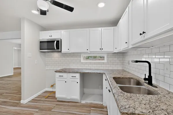 a kitchen with a sink window and cabinets