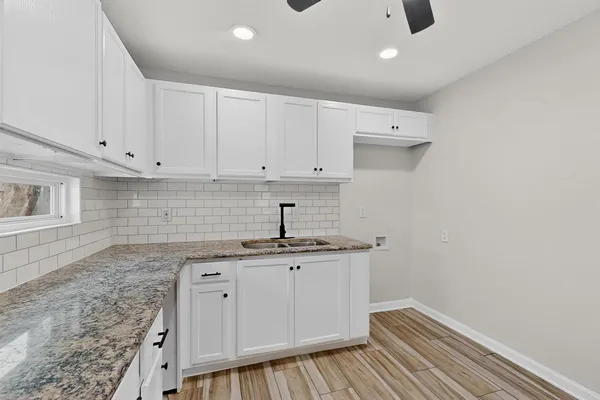 a view of an empty room with wooden floor and closet