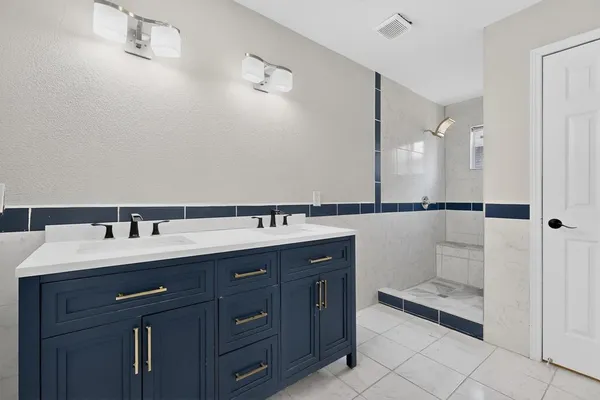 a bathroom with a granite countertop sink and white shower