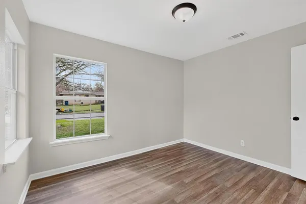 a view of room with window and wooden floor