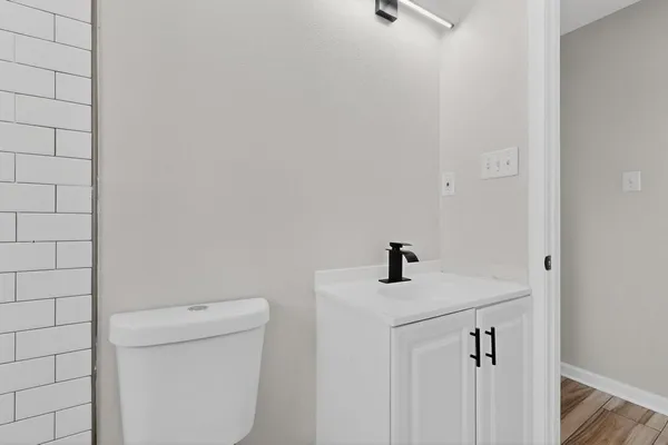 a view of an empty room with wooden floor and closet