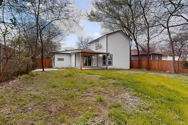 a view of a yard with a house and a large tree