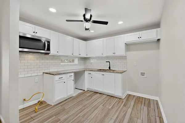 a spacious bedroom with a bed a couch and a potted plant