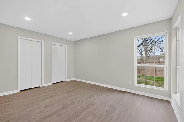 a view of empty room with wooden floor and ceiling fan