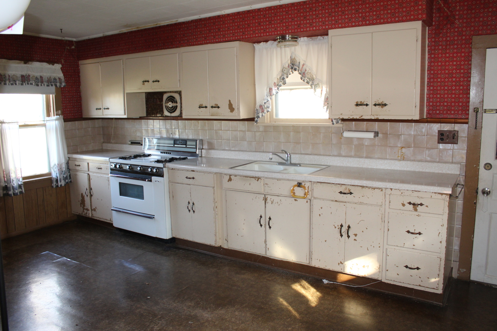 9729 Beaver Valley Road Belvidere, IL 61008 - Photo 34 of 39 a kitchen with white cabinets a sink a stove and wooden floors
