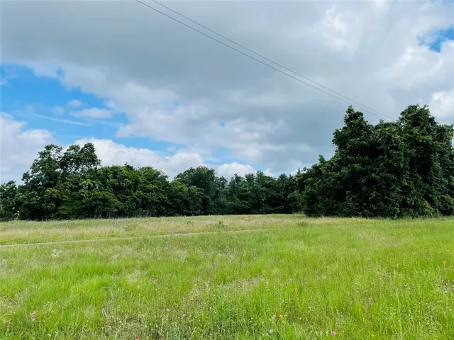 a view of a green field with wooden fence