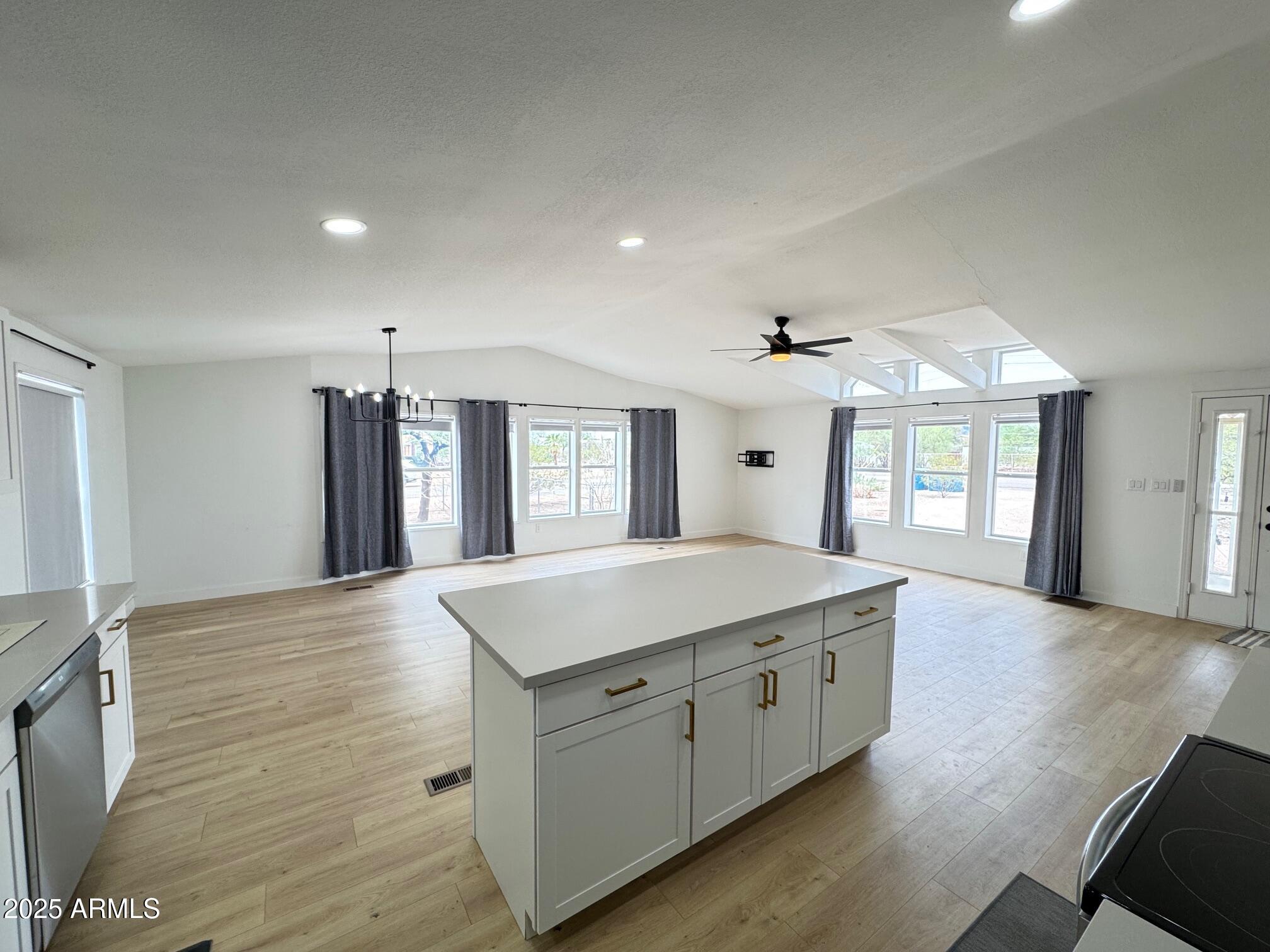 1835 East 20th Avenue Apache Junction, AZ 85119 - Photo 11 of 29 a hall with kitchen island white cabinets and wooden floor