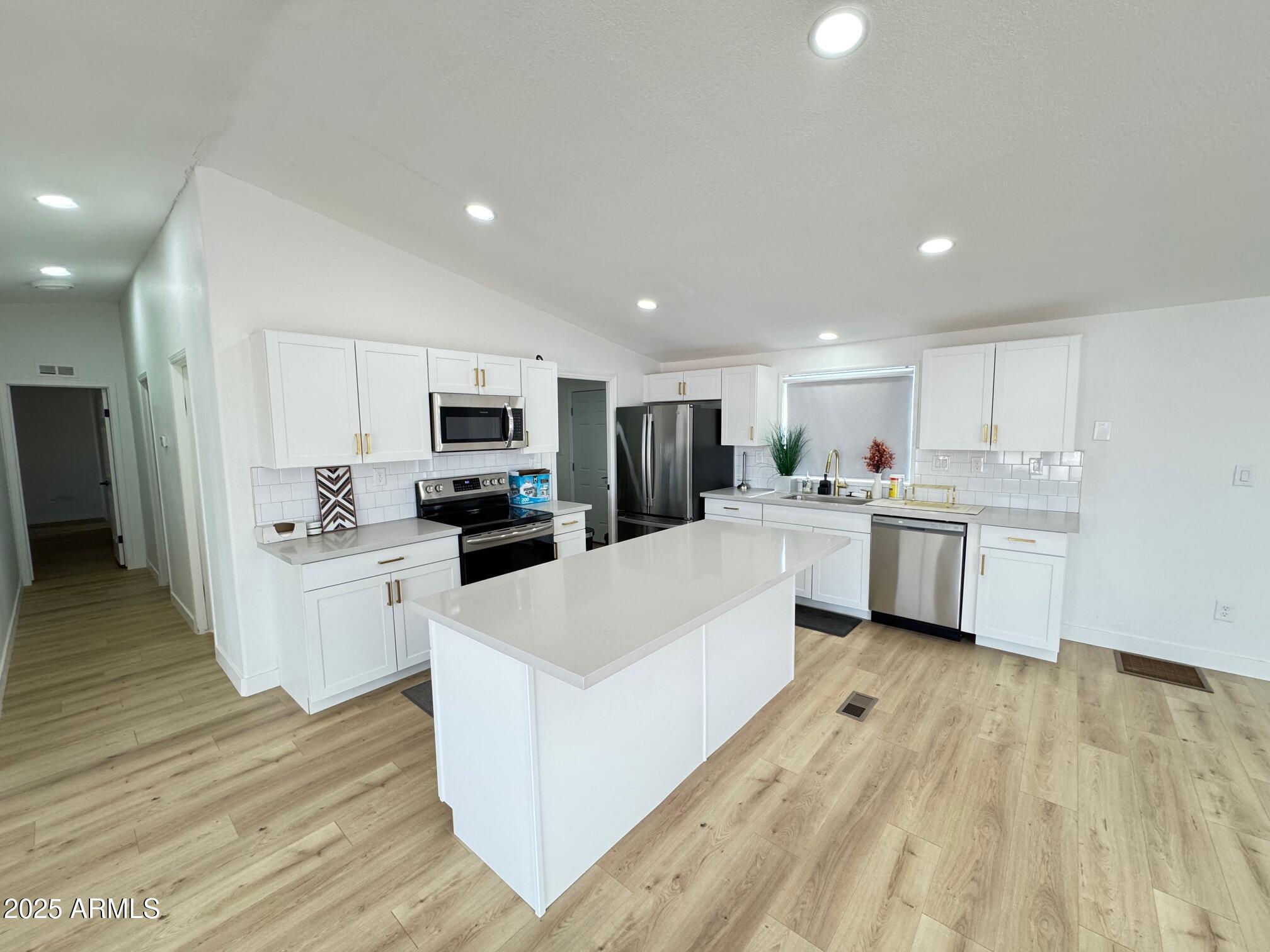 1835 East 20th Avenue Apache Junction, AZ 85119 - Photo 9 of 29 a kitchen with white cabinets and white appliances