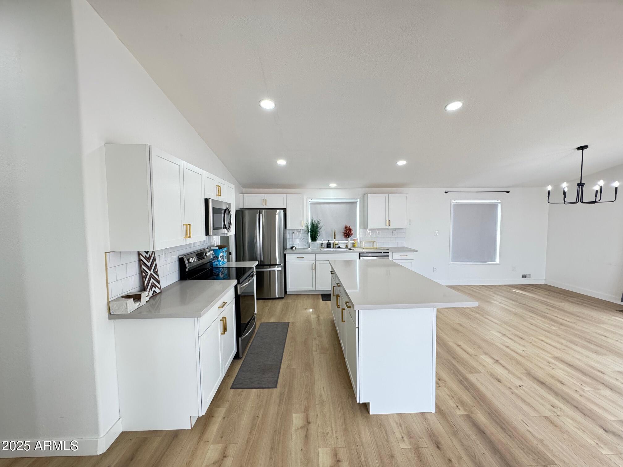 1835 East 20th Avenue Apache Junction, AZ 85119 - Photo 10 of 29 a view of a kitchen with kitchen island a sink wooden floor and a view of living room