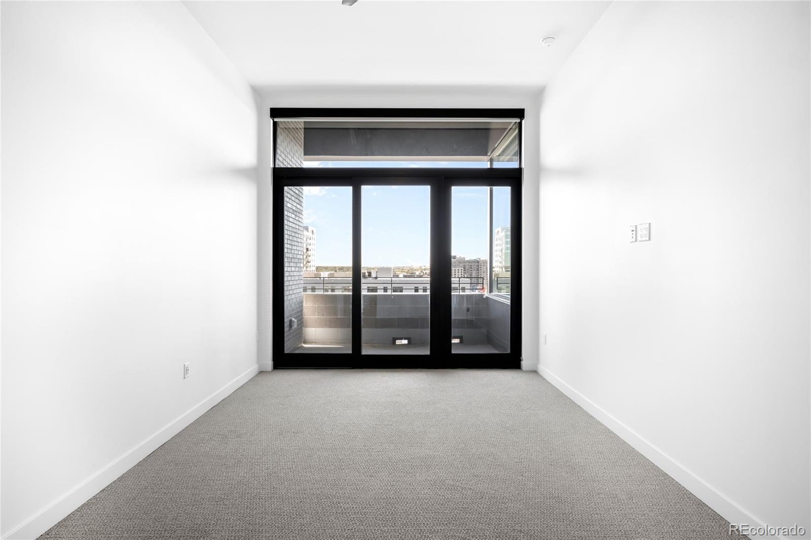3520 Chestnut Place, Unit 1206 Denver, CO 80216 - Photo 15 of 41 a view of an empty room with wooden floor and a window