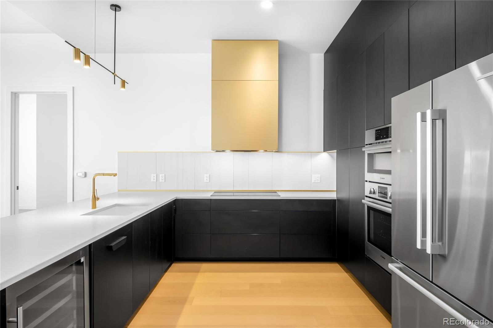 3520 Chestnut Place, Unit 1206 Denver, CO 80216 - Photo 5 of 41 a kitchen with a refrigerator and a sink
