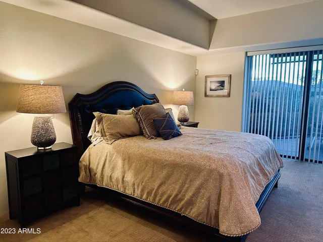 a bedroom with a bed and painting on the wall