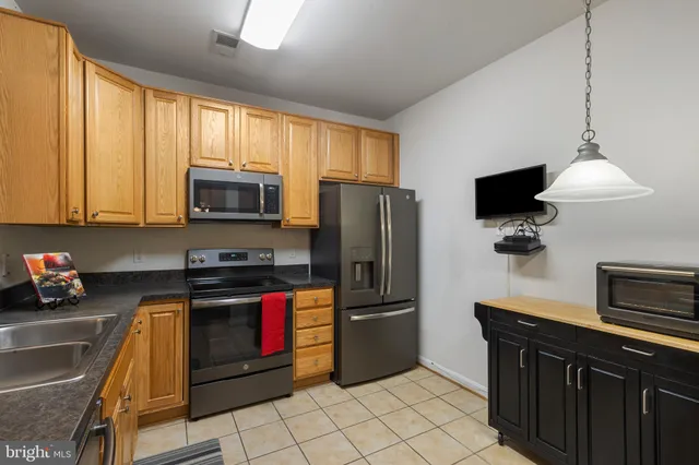 a kitchen with stainless steel appliances granite countertop a refrigerator sink and microwave