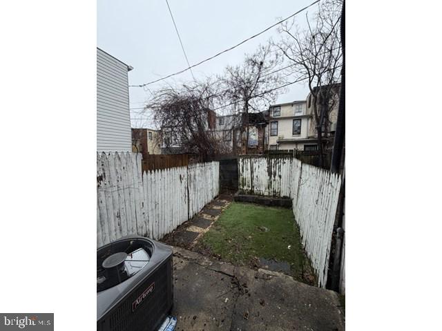 1609 Lemmon Street Baltimore, MD 21223 - Photo 15 of 16 a view of a house with a small yard and wooden fence