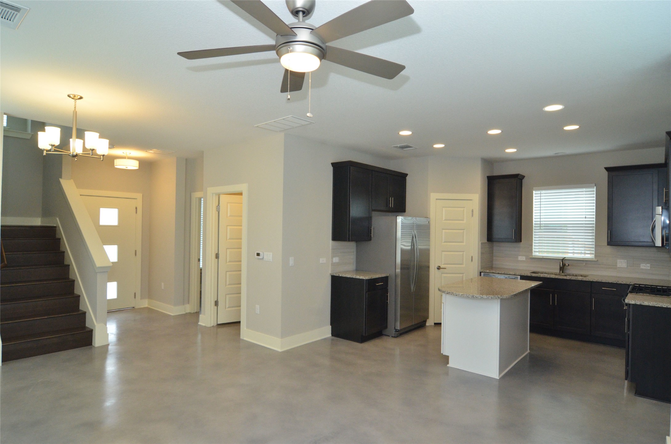 1916 Cleese Drive Austin, TX 78741 - Photo 3 of 36 An open-concept living space integrates a modern kitchen and dining area with clean, polished flooring.