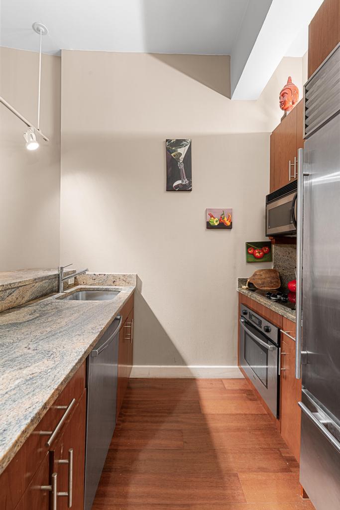 80 John Street, Unit 2A Manhattan, NY 10038 - Photo 4 of 10 a kitchen with stainless steel appliances granite countertop a sink stove and refrigerator