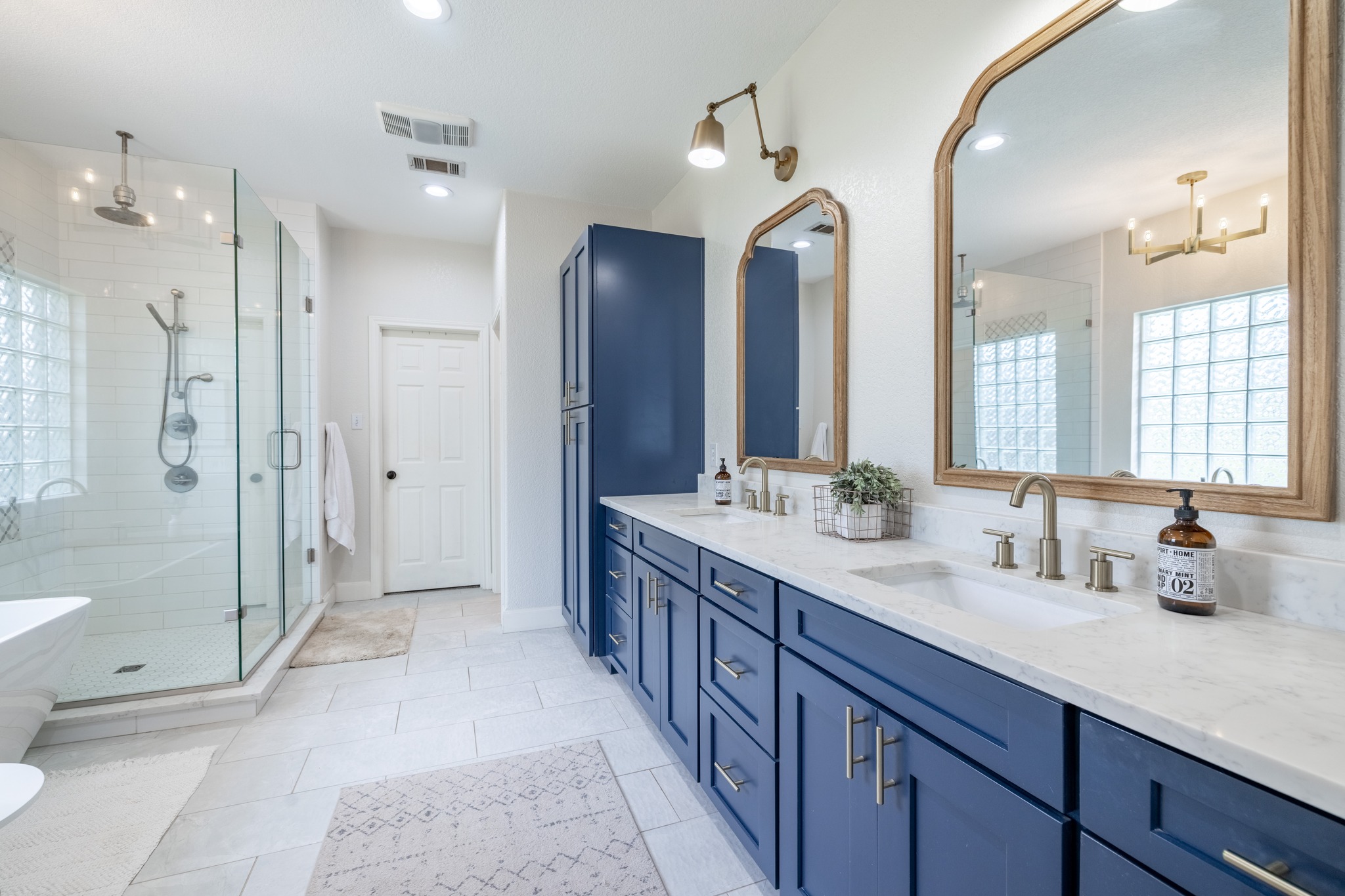 108 Kyle Lane Georgetown, TX 78633 - Photo 11 of 26 Bathroom featuring a double vanity with deep blue cabinetry, light countertops, and framed mirrors