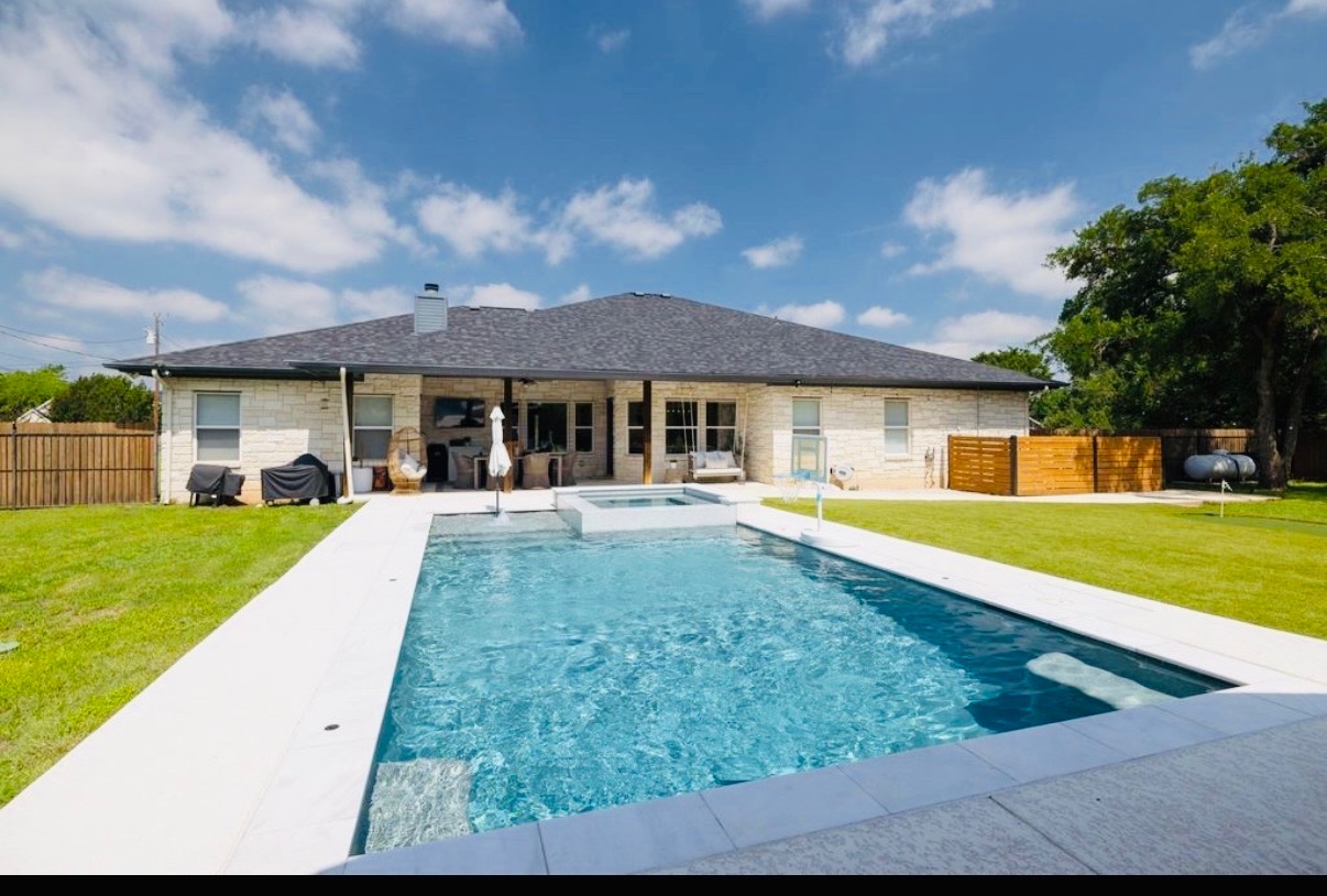 108 Kyle Lane Georgetown, TX 78633 - Photo 20 of 26 Rectangular inground pool with integrated spa and surrounding white coping