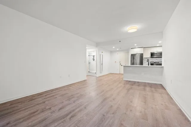 a view of a kitchen with wooden floor and a sink