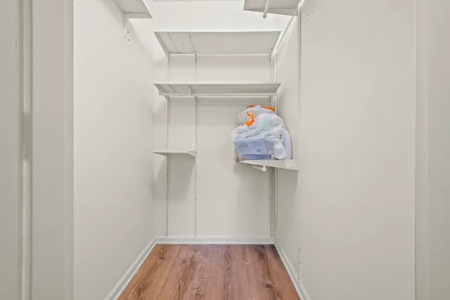 a view of walk in closet with clothes and shoes