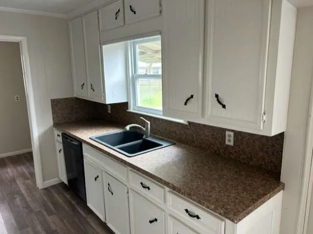 a kitchen with granite countertop a sink a stove and cabinets
