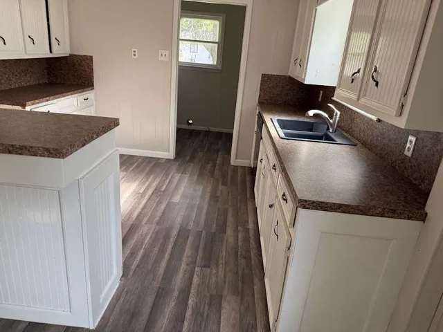 a kitchen with granite countertop a sink and a stove top oven