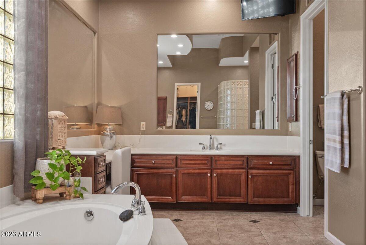 6427 South Magic Court Gilbert, AZ 85298 - Photo 31 of 71 a spacious bathroom with a granite countertop sink and a mirror