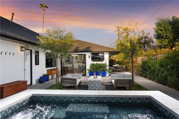 a view of a house with backyard and sitting area