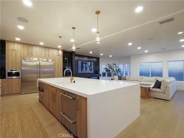 a large white kitchen with a large window and stainless steel appliances