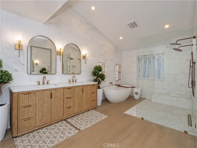 a bathroom with a tub shower sink and mirror