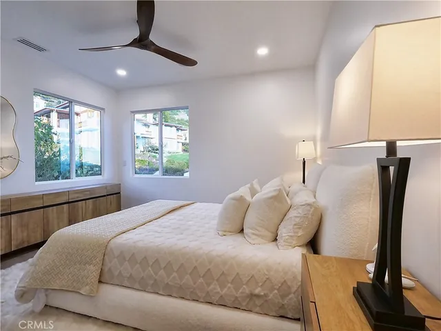 a bedroom with a large bed and a chandelier